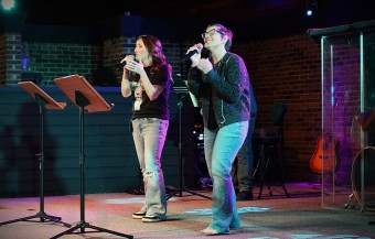 women singing on a church stage
