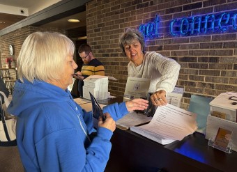 a woman handing out information at a welcome booth