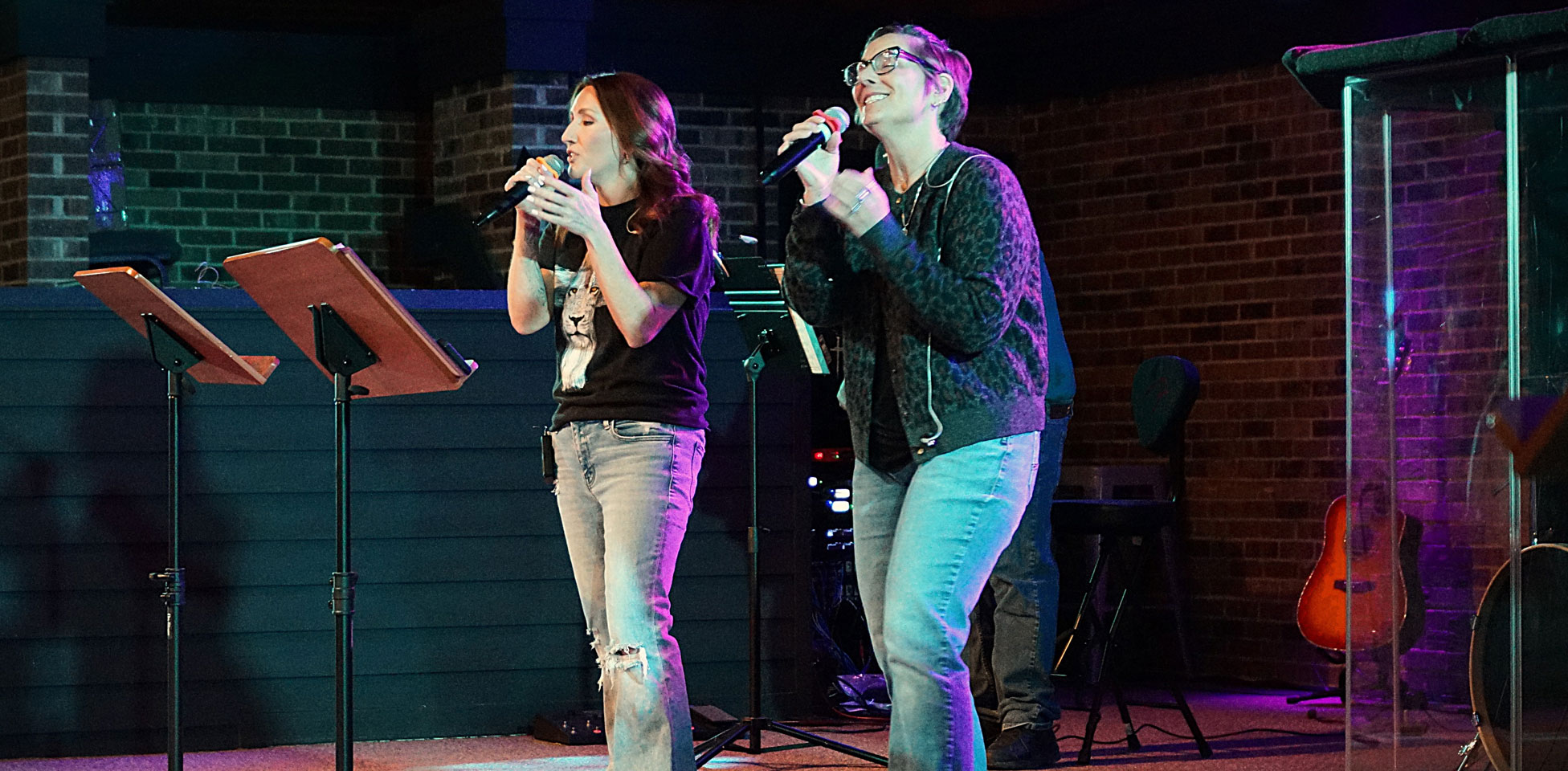 two women singing on a stage